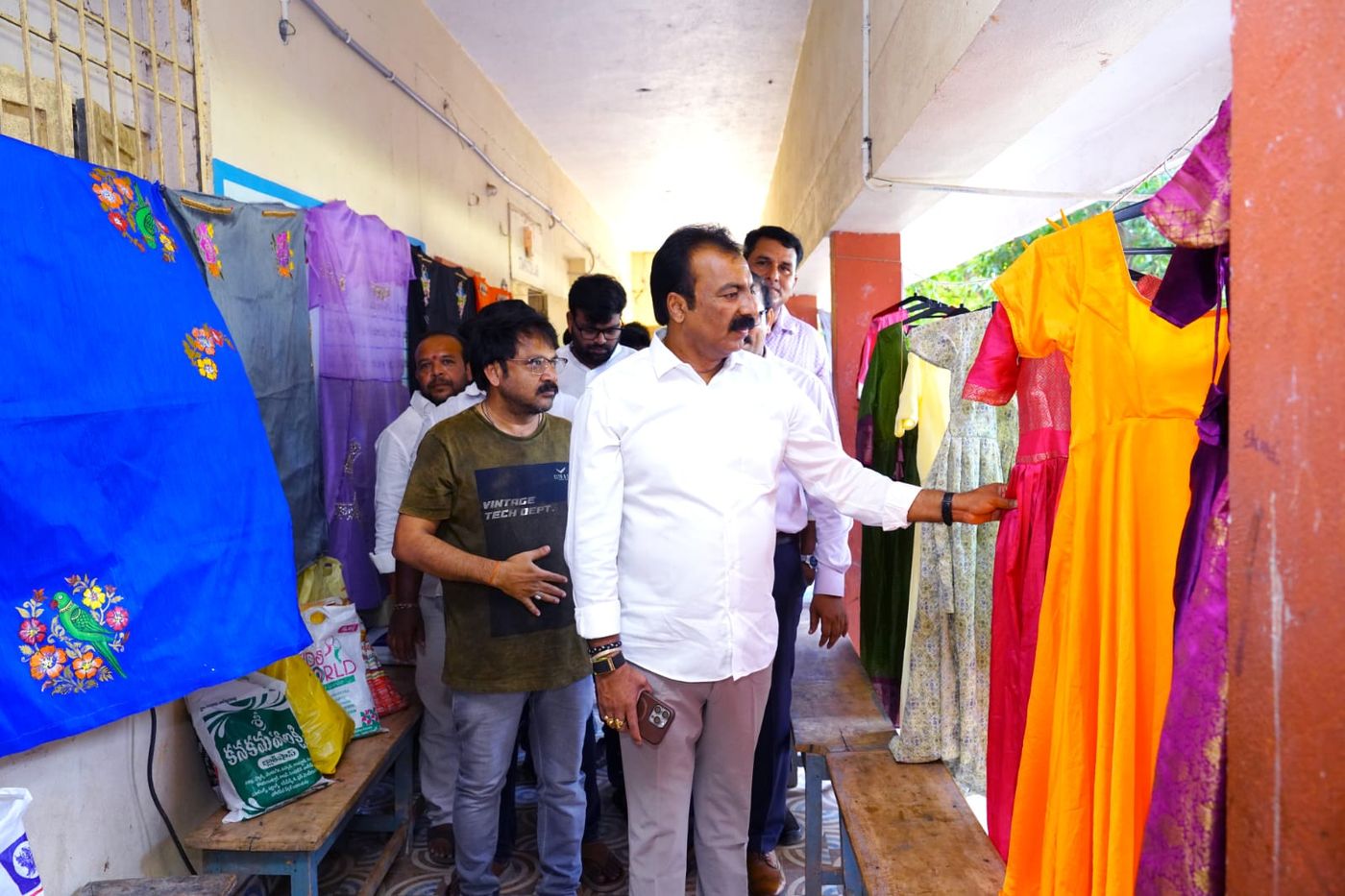 Dignitaries reviewing tailored garments made by trainees